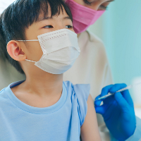 Asian child receives vaccination while in a comfort position